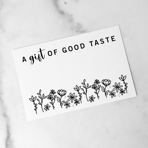 A gift enclosure card with the text 'A gift of good taste' followed by a hand-drawn floral pattern.