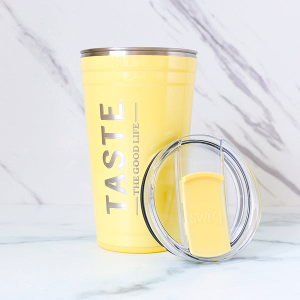 Yellow tumbler with 'TASTE THE GOOD LIFE' text on a marble background