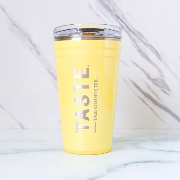 Yellow tumbler with 'TASTE. THE GOOD LIFE' text on a white background