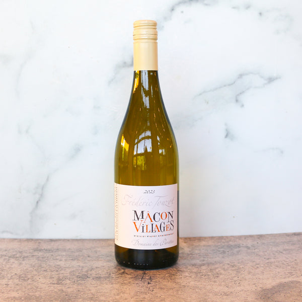 A bottle of DOMAINE DES PARETTES MACON-VILLAGES CHARDONNAY available at TASTE across costal Virginia and Richmond and online at TASTE.online on a wooden surface with a marble background
