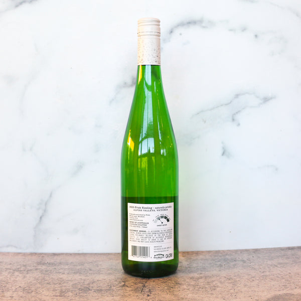 Green wine bottle with white label on a marble background