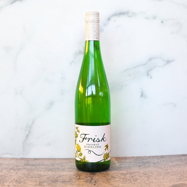 A bottle of Frisk Prickly Riesling available at TASTE across costal Virginia and Richmond and online at TASTE.online in a grreen wine bottle with a white label on a marble surface