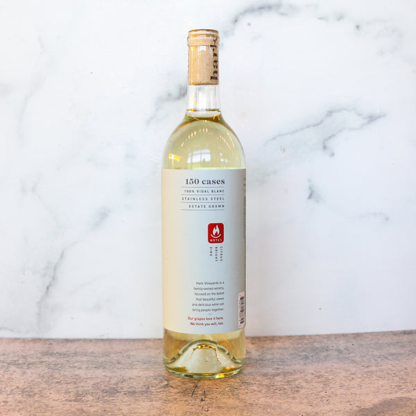 Bottle of white wine with a label on a marble background. This is Hark Vinyards Virginia Verde available at TASTE across costal Virginia and Richmond and online at TASTE.online