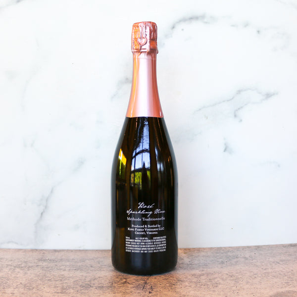 Bottle of sparkling wine on a wooden surface with a marble background