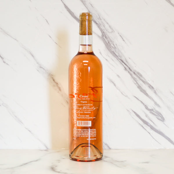 Bottle of rose wine on a marble surface with a white marble background