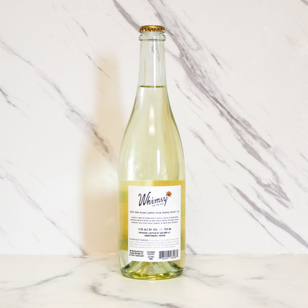 Bottle of 'Love Song' with an orange label featuring a face design on a marble background, available at TASTE across costal Virginia and Richmond and online at TASTE.online