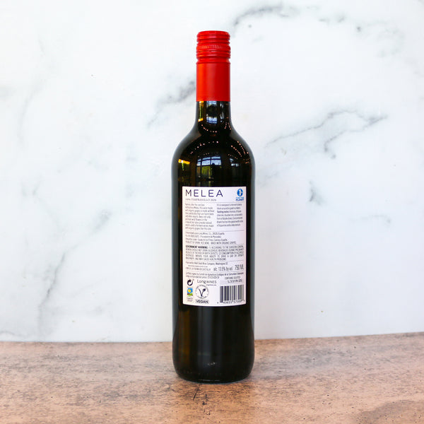 Wine bottle with red cap and visible label on a marble background