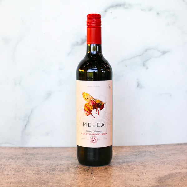 Bottle of Melea wine on a wooden surface with a marble background, available at TASTE across costal Virginia and Richmond and online at TASTE.online
