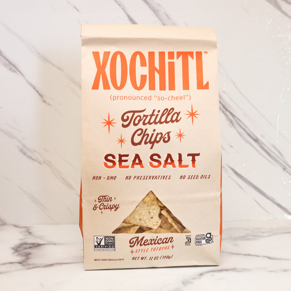 Xochitl Tortilla Chips Sea Salt packaging on a marble background. These are the tortilla chips in many TASTE signature gifts.