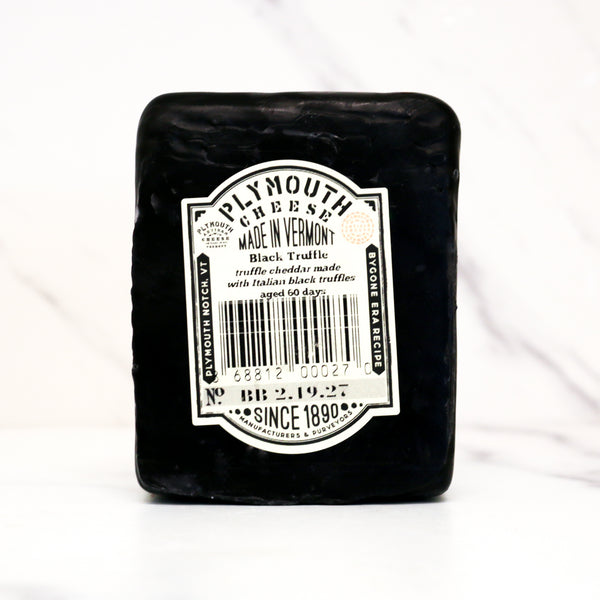 Block of Plymouth Cheese with a label on a white background