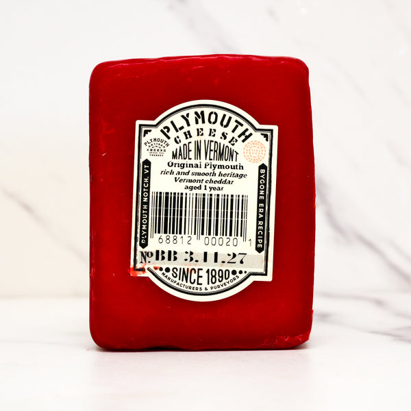 Red Plymouth Cheese block with a label on a white background