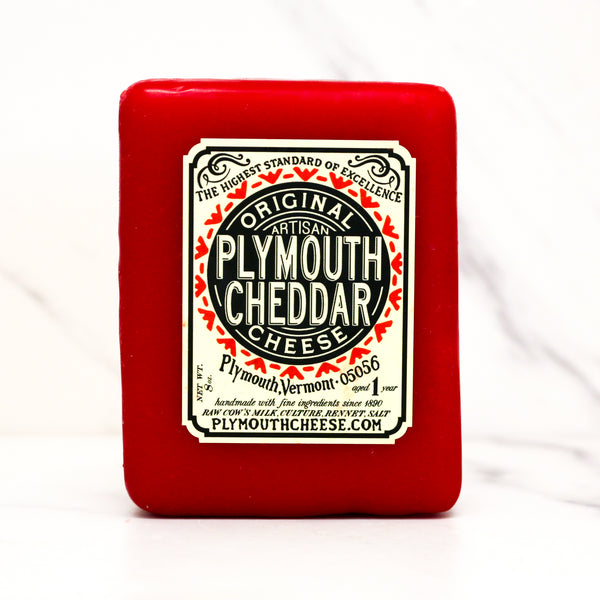 Red packaging of Plymouth Cheddar cheese with a white label on a white background