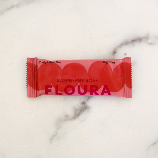 Red package of FLOURA Raspberry Rose fiber bar on a marble background