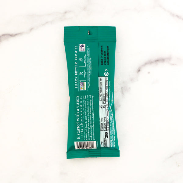 Green snack bar package on a white marble background