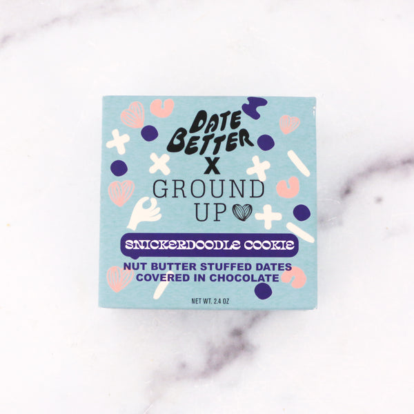Box of Date Better x Ground Up Snickerdoodle Cookie on a marble surface