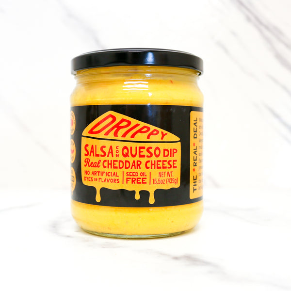 Jar of Drippy Salsa Queso Dip with a black lid on a white background