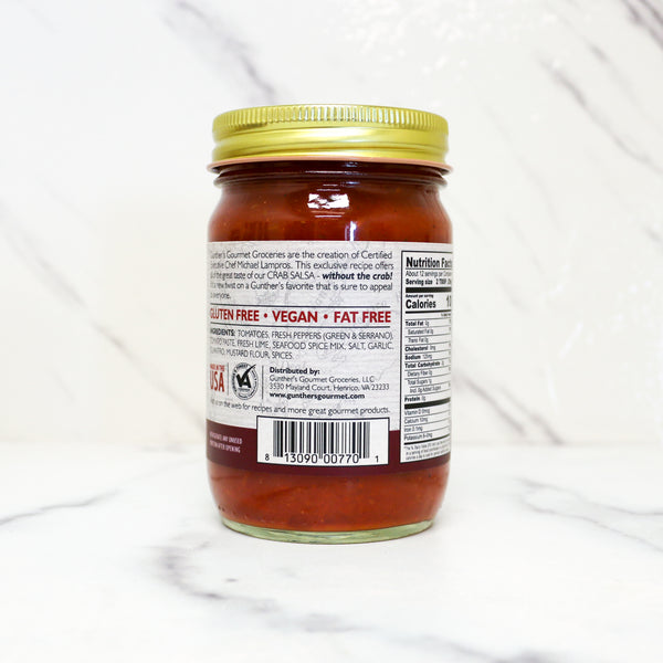 Jar of sauce with a gold lid on a white background