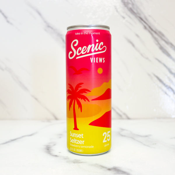 Scenic Views Sunset Seltzer can with palm tree design on a white marble background