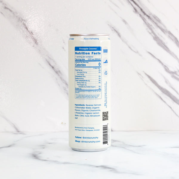 Can of Crunchy Hydration pineapple coconut drink with nutrition facts label on a marble background