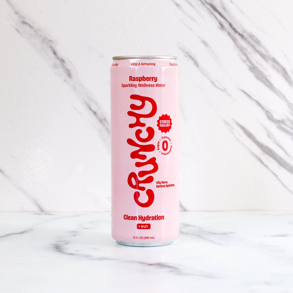Pink can of Crunchy Raspberry sparkling wellness water on a marble background