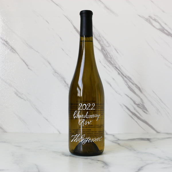 Wine bottle labeled '2022 Chardonnay Riv' on a marble surface
