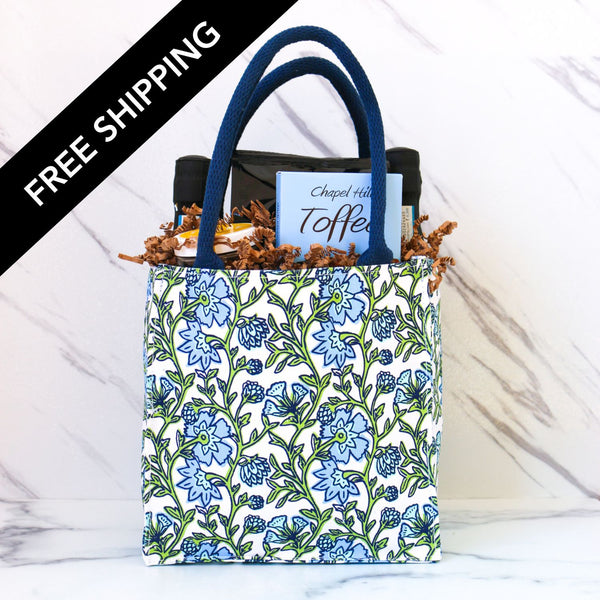 Floral-patterned tote bag with blue handles on a white background