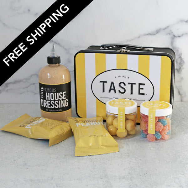 Collection of food items including a bottle, packets, and jars on a marble surface with 'Taste' branded tin.