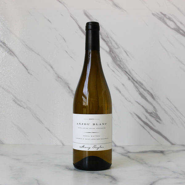 Wine bottle labeled 'Anjou Blanc' on a marble background