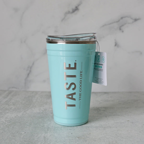 Light blue insulated tumbler with sippy lid and featuring light metallic flake finish and beachy vibes, featuring the "TASTE, The Good Life" logo in rose gold text. 