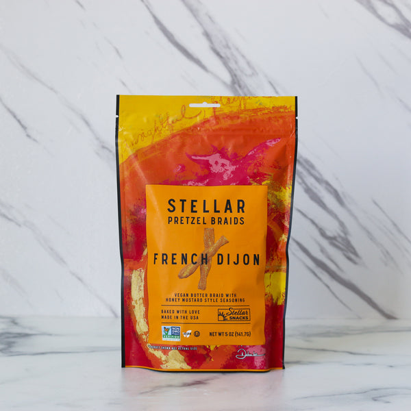 Packaged snack with 'Stellar Pretzel Braids French Dijon' label on a marble background