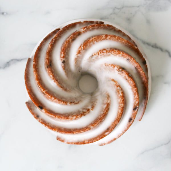 Decorative amazing top-down shot of TASTE Bakehouse bundt cake with a spiral pattern on a marble surface
