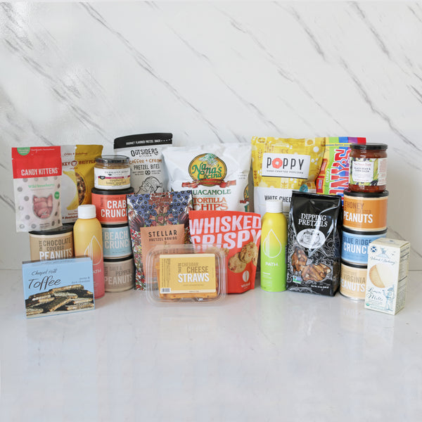 A variety of snack boxes and packages arranged on a marble surface, including TASTE and other brands, many types of snacks and sweets 