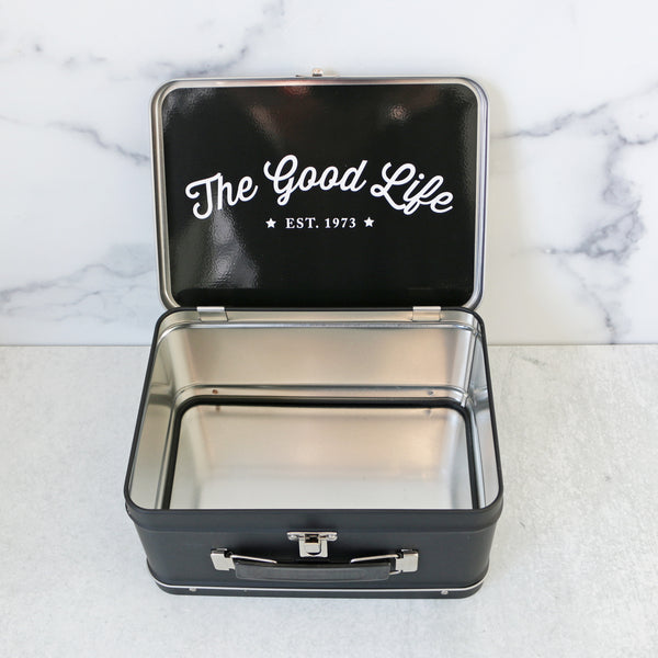 A yellow and white striped metal lunch box with TASTE branding 