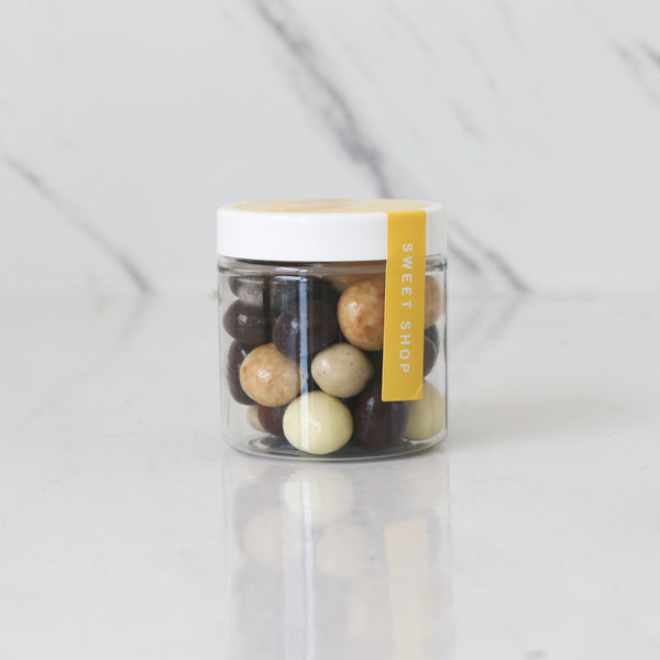 Jar of assorted chocolates with a  TASTE 'Sweet Shop' label on a light gray background