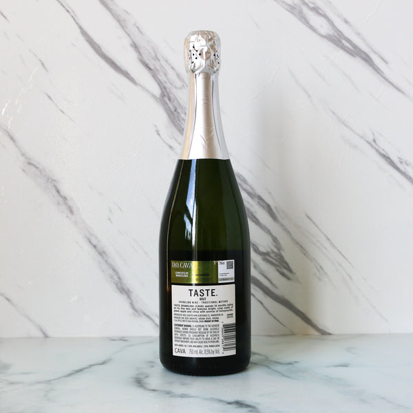 Bottle of TASTE House cava brut sparkling wine with a silver foil cap on a marble surface