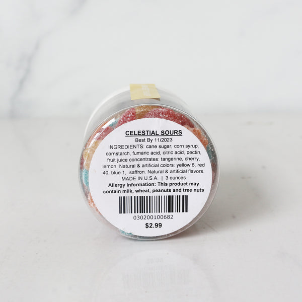 the bottom of a clear jar filled with colorful star-shaped gummy candies with a label on the lid.