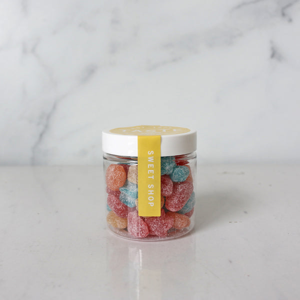 A clear jar filled with colorful star-shaped gummy candies with a label on the lid.