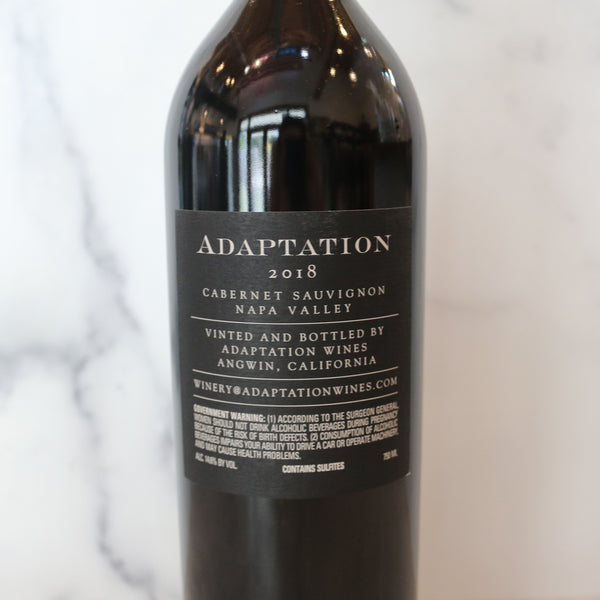 back of a bottle of Abiouness Ten Rows Carneros Pinot Noir wine positioned in front of a marble background.