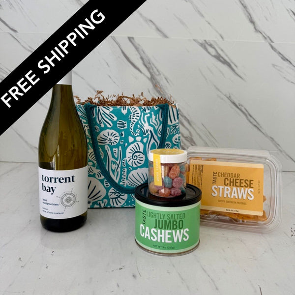 a bottle of torrent bay sav blanc, some snacks and a canvas bag coverd with  a painting of sea life