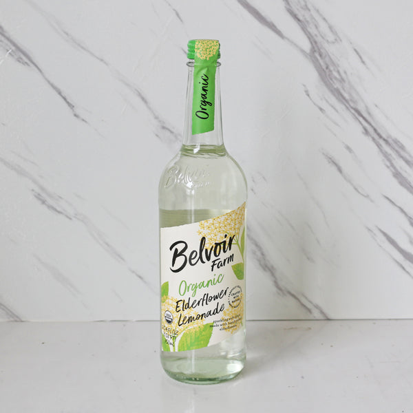 A bottle of Belvoir Farm Organico Sparkling Elderflower beverage with a label that indicates it is organic and contains elderflower, lemon, and water.