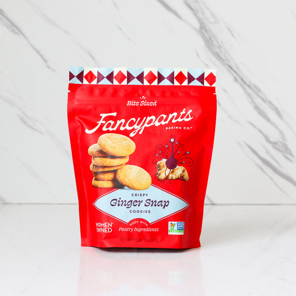 Red package of Fancypants Crispy Ginger Snap Cookies on a white marble background