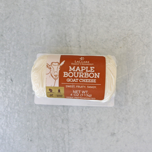 Packaged LaClare Maple Bourbon Goat Cheese on a stone surface.