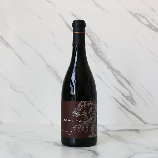 Wine bottle labeled 'Mending Wall' on a marble surface