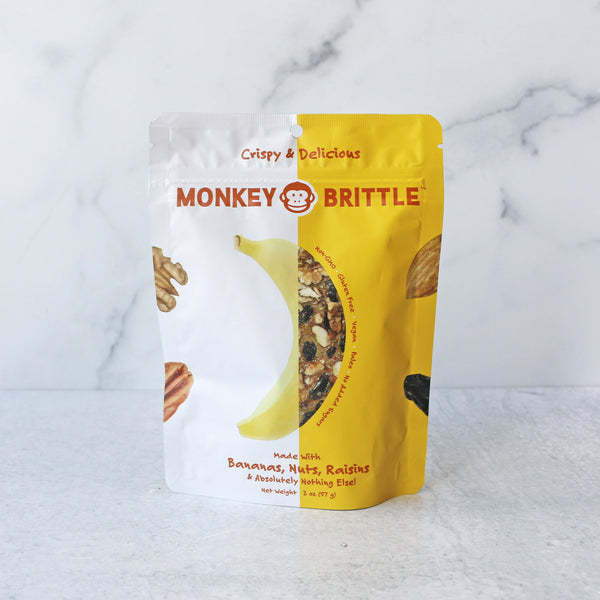 A packaged snack product called Monkey Brittle from huggins family farm, which is a banana nut bread flavored snack made from organic bananas, nuts, and raisins.