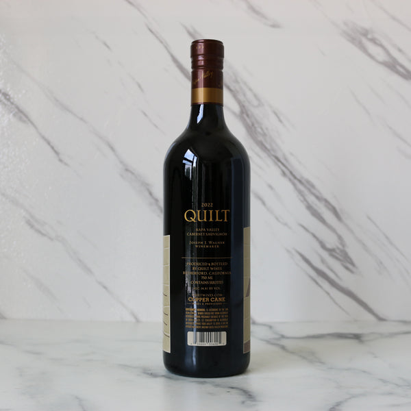 Wine bottle labeled 'Quilt' on a marble surface
