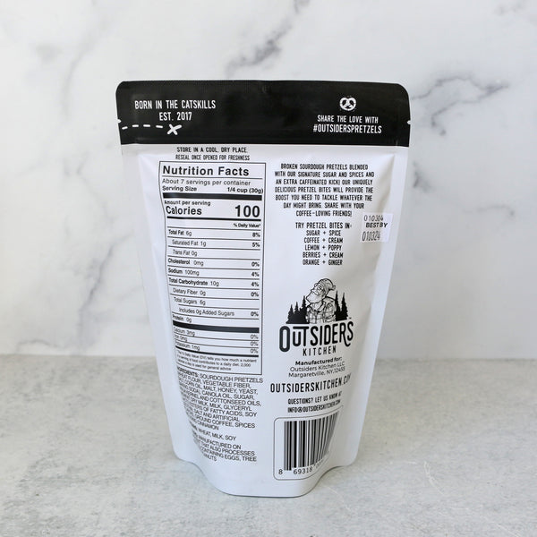 the back of a package of Outsiders Kitchen Coffee & Cream Pretzel Bites against a marble background. Shows nutrition facts and ingredients