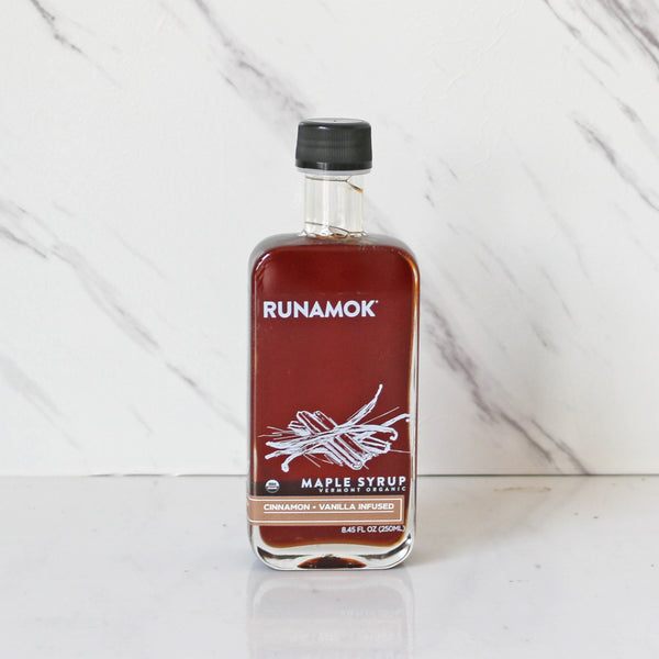 A 250mL bottle of Runamok maple syrup with cinnamon and vanilla flavors, placed on a marble surface.