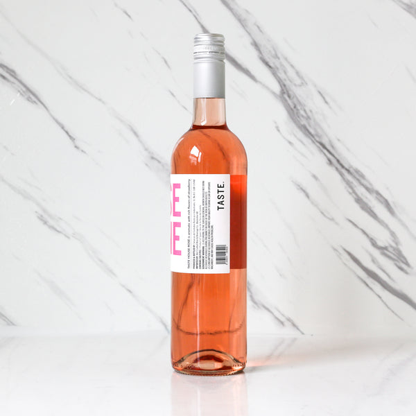 TASTE House Rose bottle in front of a marble background, showing label text