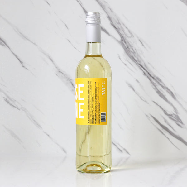Bottle of TASTE House white wine with a yellow label and text on a marble background