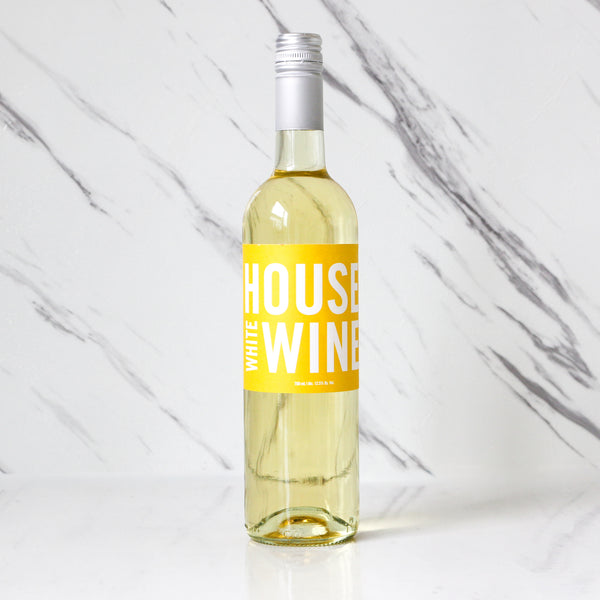 Bottle of TASTE House white wine with a yellow label on a marble background